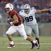 Stanford's Christian McCaffrey runs past Kansas State's Trey Dishon for a 35-yard touchdown in the first half on Friday night. McCaffrey scores 2 TDs in win