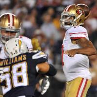 San Francisco QB Colin Kaepernick throws a pass as San Diego's Tourek Williams defends in preseason action on Thursday. The 49ers won 31-21. 49ers win after Kaepernick kneels for anthem