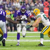 Minnesota's Adrian Peterson (center) suffered a knee injury in a win over Green Bay last week. Surgery puts Peterson's season in doubt