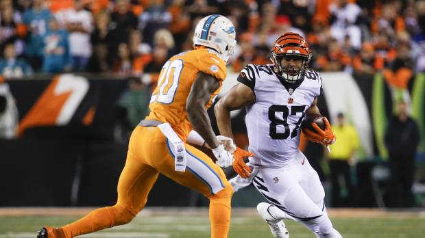 Cincinnati's C.J. Uzomah runs with the ball as Miami's Reshad Jones pursues in the first half on Thursday night. Green shines as Bengals smother Dolphins