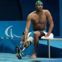 Swimmer Achmat Hassiem puts on his prosthesis after competing in the men’s 100-meter freestyle heats at the 2016 Rio Paralympics on Tuesday. 'Shark Boy' making splash in, out of Paralympic pool