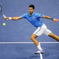 Novak Djokovic plays a shot during his U.S. Open quarterfinal against Jo-Wilfried Tsonga at Flushing Meadows on Tuesday. Djokovic moves into semis
