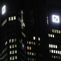 Deutsche Bank’s logos are pictured at the headquarters in Frankfurt, Germany, Friday. Worries over the financial health of Deutsche Bank returned to the fore Friday, sending the company’s share price into a tailspin and to a record low. Germany Inc. execs stand with embattled Deutsche Bank