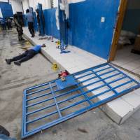 A guard lies dead inside the Civil Prison in the coastal town of Arcahaiea, Haiti, Saturday. Over 100 inmates escaped after they overpowered guards who were escorting them to a bathing area. Over 100 inmates at Haiti prison stage mutiny, kill guard and flee