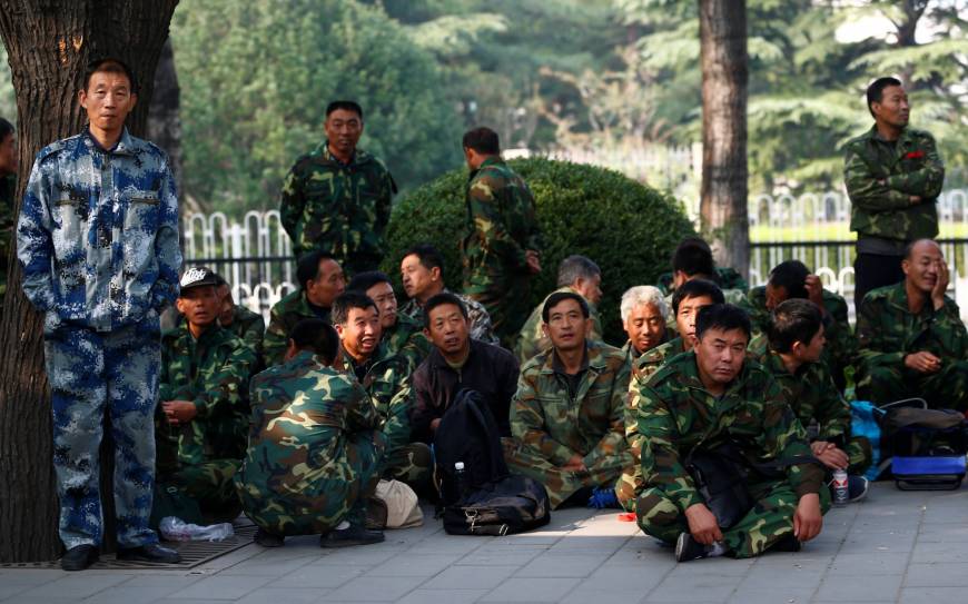 Uniformed people take part in a protest outside the Bayi Building, a major military building in Beijing, on Tuesday.