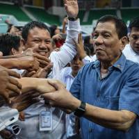 Philippine President Rodrigo Duterte shakes hands with Philippine nationals living in Brunei after delivering a speech during an official visit to the country Sunday. Duterte visit to Beijing likely to be heavy on business talks, light on South China Sea