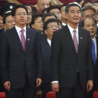 Hong Kong Chief Executive Leung Chun-ying (center) and Zhang Xiaoming (left), director of the Liaison Office of the Central People's Government in the Hong Kong Special Administrative Region, attend a flag-raising ceremony in celebration of China's National Day in the city Saturday. Hong Kong's chief executive calls for unity with China as protesters gather