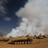 Iraqi forces gather after the liberation of a village south of Mosul on Friday, as toxic smoke is seen over the area after Islamic State militants set fire to a sulphur factory. Sulphur cloud from IS-torched Iraq plant kills two civilians