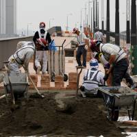 Construction workers lay a surface on Sept. 27 at the Toyosu wholesale market, which is slated to take over from Tsukiji. Toxin levels are low, but jury out on long-term risks at Toyosu market