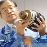 A Tokyo Electric Power Co. Holdings Inc. official shows a section of the type of cable that likely caught fire, during a news conference in Tokyo on Wednesday evening. Tepco substation blaze blamed on aging cable insulation