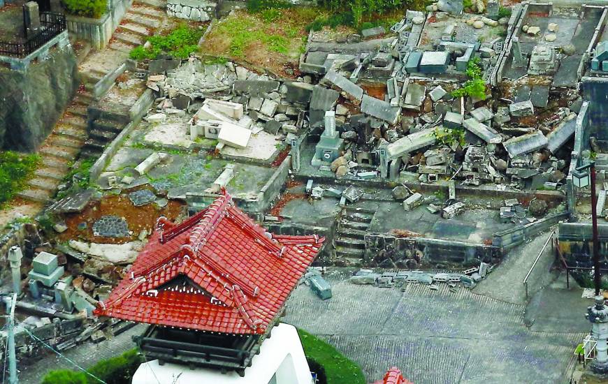 This aerial photo shows broken grave markers and collapsed walls at a cemetery in Kurayoshi, Tottori Prefecture, following a strong earthquake that shook the area Friday. | KYODO