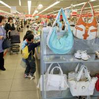 Shoppers browse through clothes in a Shimamura Co. outlet in Saitama Prefecture. No-frills clothier Shimamura finds favor in sluggish Japan, tops Uniqlo in income growth