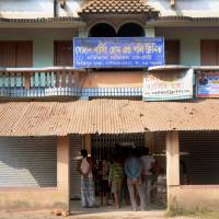 Local residents stand in front of the Sohan Nursing Home and Poly Clinic on Nov. 23 after an officer from the Criminal Investigation Department of the West Bengal police sealed the main Nursing Home, in Baduria around 65 km west of Kolkata. Twelve people have been arrested in eastern India for trafficking newborn babies, who were smuggled out of clinics in biscuit boxes, police said. India cops find remains of five newborns, rescue 10 babies in illegal adoption ring bust