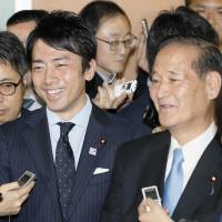 Shinjiro Koizumi (front left), head of the LDP policy panel’s Agriculture and Forestry Division, and veteran LDP lawmaker Koya Nishikawa speak to reporters on Friday. KYODO LDP adopts farm reforms requiring numerical targets from JA but backs off timeline