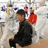 People living near the Ikata nuclear plant in Ehime Prefecture are screened for radiation in Oita Prefecture, where they evacuated during a disaster drill Friday. 23,000 take part in nuclear evacuation drill at Ikata plant on Shikoku