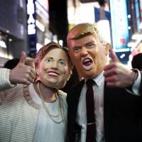 Boo: People wear costumes of U.S. presidential candidates Hillary Clinton and Donald Trump as they take part in a Halloween parade in Tokyo on Oct. 29. A guide to following U.S. Election Day for viewers in Japan