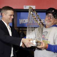 Cubs president Theo Epstein (left) and manager Joe Maddon, holding the winner’s trophy after Game 7 of the Fall Classic in Cleveland after midnight on Thursday, teamed up to lead Chicago to the 2016 World Series title. Late-night rain delay helps Cubs capture elusive title