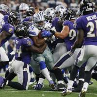 The Ravens defense tries to bring down Cowboys running back Ezekiel Elliott on Sunday. Cowboys keep rolling with victory against Ravens