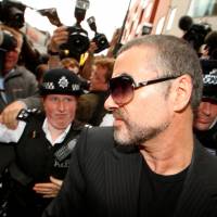 British singer George Michael is escorted out of Highbury Corner Magistrates Court in London on Aug. 24, 2010. Madonna, Elton John lead online tributes for George Michael