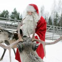 A man dressed in a Santa Claus costume feeds reindeer at a farm in preparation for Christmas in Rovaniemi, northern Finland, in December 2007. Lighter presents and smaller sleighs needed as Santa's reindeer shrink in size