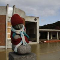 A stone statue stands near tsunami-hit Okawa Elementary School in Ishinomaki, Miyagi Prefecture, in March 2012. The education ministry plans to make classes on disaster response a mandatory subject for university students aiming to become teachers. Disaster preparation course to be mandatory for aspiring teachers
