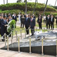 Prime Minister Shinzo Abe lays flowers as other officials look on at the Ehime Maru Memorial in Honolulu on Monday. Abe pays tribute to victims of 2001 Ehime Maru accident