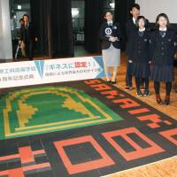 Students and teachers show off a mosaic made of 36,400 incense sticks in Osaka that set a Guinness World Record Saturday at Sakai Technology High School. Osaka students set Guinness record with burial mound mosaic made of incense sticks