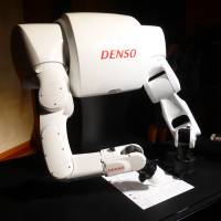 A robot developed by auto parts maker Denso Corp. writes Torobo-kun’s answers on paper during a demonstration on Nov. 14 in Chiyoda Ward, Tokyo. Quest for artificial intelligence highlights lack of critical thinking skills in humans