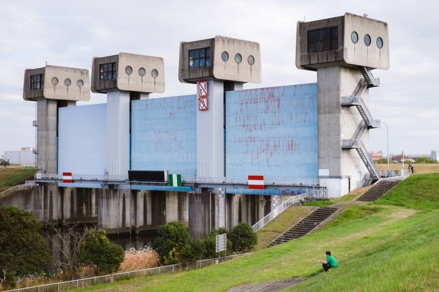 Grass and concrete: A man relaxes near the Iwabuchi Water Gate. The surrounding area is a popular space for cycling, fishing and picnics.