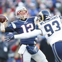 Patriots quarterback Tom Brady passes while under pressure from the Rams’ Ethan Westbrooks on Sunday in Foxborough, Massachusetts. Brady earns record 201st win as Patriots beat Rams
