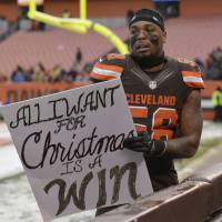 Browns linebacker Christian Kirksey holds a sign made by a fan after the team’s 23-10 loss to the Bengals on Sunday. Browns fall to 0-13, near infamous mark