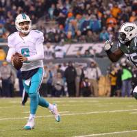 Dolphins quarterback Matt Moore looks to pass while being chased by Jets defensive tackle Anthony Johnson on Saturday. Dolphins dominate on both sides of ball in win against Jets