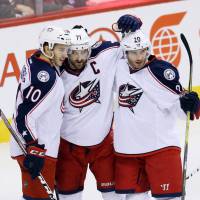 Blue Jackets center Alexander Wennberg (10) celebrates with Nick Foligno (71) and Brandon Saad after scoring against Winnipeg on Thursday. Blue Jackets extend win streak to 14