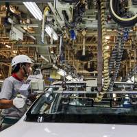 Employees assemble a Toyota Motor Corp. Hilux pickup truck at the company’s plant in Ban Pho, Thailand, in October 2015. Global salary gaps hindering automakers' efforts to lure IT workers
