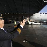 Iran Air Capt. Mehdi Jafarzadeh takes a picture of the arrival of his company’s new Airbus plane at Mehrabad airport, in Tehran Thursday. The first of 100 Airbus planes that Iran is expected to receive after its historic nuclear deal with world powers ended some sanctions landed on Thursday in the capital. Airbus delivers Iran's first new jetliner in decades after nuclear deal