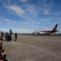 Members of the media look on as Mitsubishi Aircraft Corp.’s Mitsubishi Regional Jet touches down following its first flight at Nagoya airport in Aichi Prefecture on Nov. 11, 2015. Fifth delay announced for Japan's MRJ jet, raising concerns about new sales