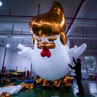 Workers inflate a giant chicken balloon resembling U.S. President-elect Donald Trump at a factory in Jiaxing, China, on Friday. It's gonna be huge: China factory hatches giant Trump chickens
