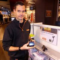 Expert City electronics shop worker Ino Andre Nilsen shows an adapter that can be plugged into a car FM radio in Oslo on Wednesday. Norway to switch off FM radio in risky, unpopular shift to digital