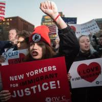 People hold signs as the Council on American Islamic Relations holds a protest over President Donald Trump’s planned ban on Muslim travel in Washington Square Park in New York on Wednesday. HRW fears Trump's 'particularly ugly' refugee ban, torture threat