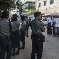 Myanmar Muslim men (at right) gather in the street outside a private meeting hall while armed policemen secure the area after hardline Buddhist nationalists stopped a Muslim ceremony at a YMCA meeting hall in Yangon on Sunday. Islamophobic tensions are boiling over in the countries amid a bloody military campaign against Rohingya communities in northern Rakhine state. Yangon Muslim festival squelched by Buddhist nationalists as police look on