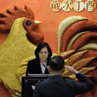 An officer salutes Taiwan President Tsai Ing-wen in front of a “Year of the Rooster” decoration while attending a lunch at the Defense Ministry in Taipei on Jan. 23. Chinese billions fail to sway Taiwan's last two allies in Africa