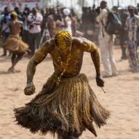 A Voodoo devotee in a trance performs Tuesday at the Voodoo Festival in Ouidah, Benin. Descendants of slaves make a voodoo pilgrimage in Benin