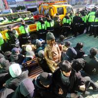 This picture taken on Dec. 28, 2016, shows South Korean activists staging a sit-in protest around a statue in Busan of a teenage girl symbolizing former “comfort women” who served as sex slaves for Japanese soldiers during World War II. Japan recalls envoys over new 'comfort women' statue in Busan