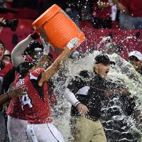 Two Falcons players dump Gatorade on head coach Dan Quinn during the fourth quarter of the NFC championship game on Sunday in Atlanta. Dominant Falcons claim NFC title