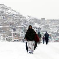 An Afghan woman walks in Kabul Sunday. Afghanistan avalanches toll tops 100 as deadly freeze sets in