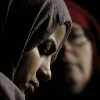 A Muslim woman listens during a protest of President Donald Trump’s travel ban in Seattle on Sunday. Critics decry Trump plan to have counter-extremism program focus only on Muslims, not on white supremacists
