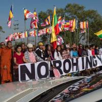 A diplomat’s limousine carrying Malaysian dignitaries passes an anti-Rohingya hard-line Buddhist group, together with Buddhist monks, rallying outside Yangon’s Thilawa port as the Malaysian ship carrying relief aid for the Rohingya Muslim minority arrives on Thursday. Malaysian ship bearing aid for Rohingya docks in Yangon amid protests