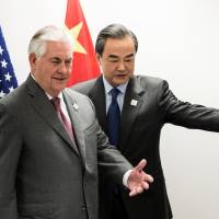 U.S. Secretary of State Rex Tillerson and Chinese Foreign Minister Wang Yi take their seats before a meeting on the sidelines of a gathering of foreign ministers of Group of 20 nations in Bonn on Friday. In first meeting with Wang, Tillerson calls on China to do more on North Korea