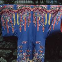 Vibrant Okinawa: A colorfully dyed garment hangs on a stone wall in Yomitan. Crafts and coral of an embattled coast