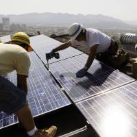 Catching some sun: Workers install solar electrical panels on the roof of a home in Glendale, California. Renewables can't deliver Paris climate goals